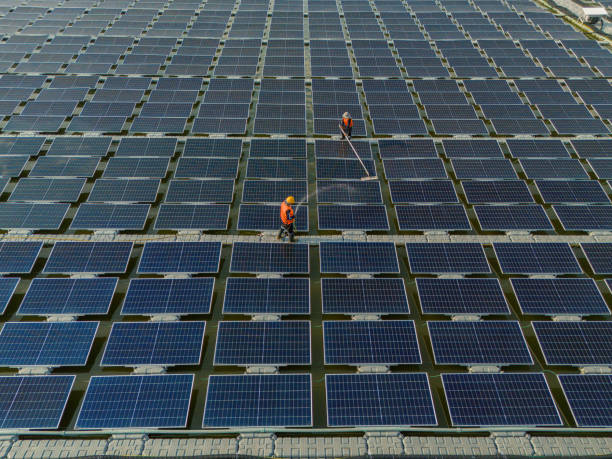 istock Worker Cleaning  floating solar panels or solar cell Platform system on the lake with brush and water. Worker cleaning solar modules in a Solar Energy Power Plant 2019757591