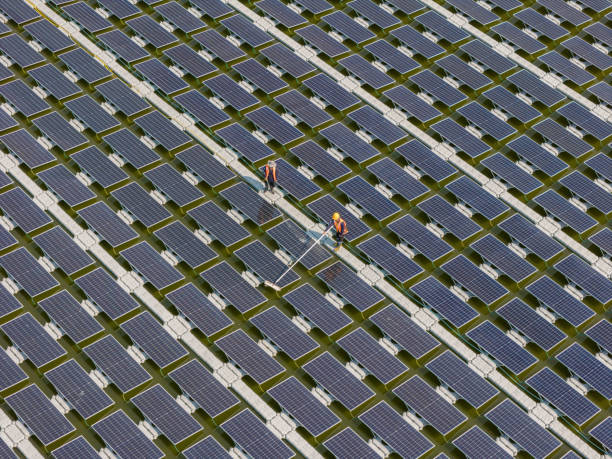 istock Worker Cleaning  floating solar panels or solar cell Platform system on the lake with brush and water. Worker cleaning solar modules in a Solar Energy Power Plant 2019757610