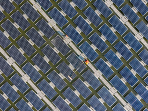 istock Worker Cleaning  floating solar panels or solar cell Platform system on the lake with brush and water. Worker cleaning solar modules in a Solar Energy Power Plant 2019757611