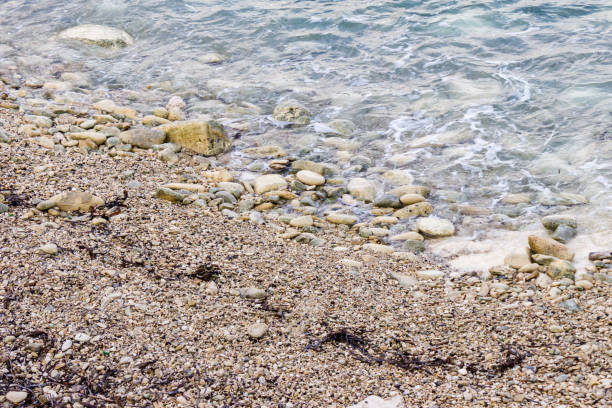 Marina di Pisa, Province of Pisa, Italy - November 4, 2024: View of the beach with snow-white stones. White stone pebbles.