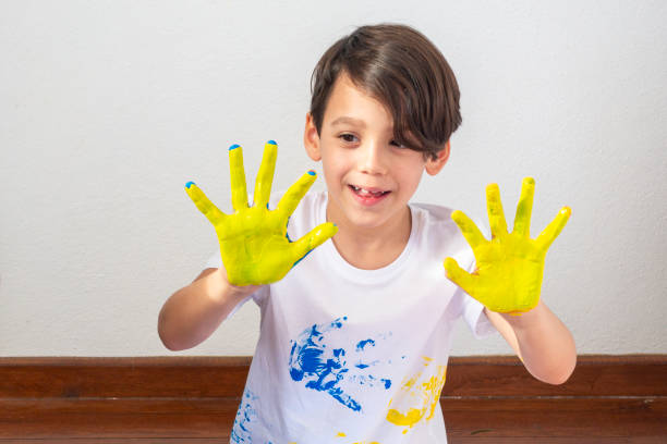 Boy Showing Colorful Paint on His Hands.