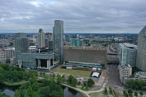The Hague is the country's administrative centre and its seat of government, and while the official capital of the Netherlands. The image shows the cityscape with several large office buildings, captured during summer season.