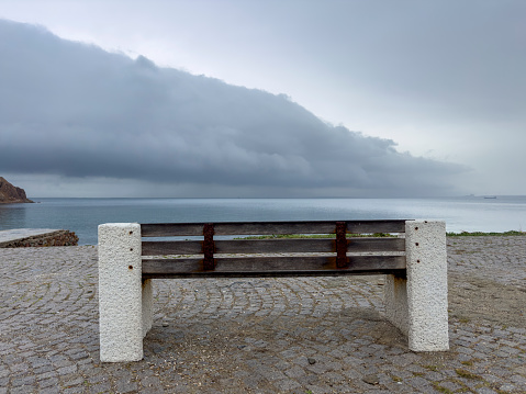 Storm clouds and calm sea. No people. Coast of Bozcaada in the northern Aegean Sea. Bench.
