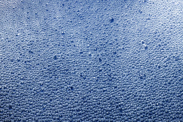 Transparent window blue raindrops. Humidity condensation texture. Blue color water.