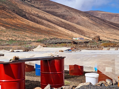 Industrial red, steel barrels in volcanic deserted landscape