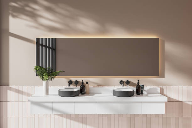 istock Beige hotel bathroom interior with double sink and minimalist accessories 2019887036
