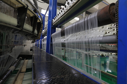 The mechanical equipment of the plastic weaving production line is running in a factory