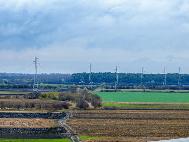From an aerial perspective, power lines form a labyrinth through fields, symbolizing the intricate network of energy transmission.