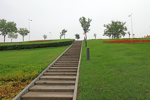 The stone steps are in the green grass in a park, North China