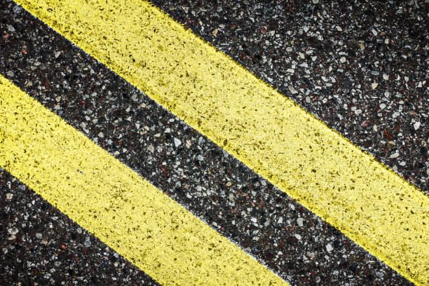 two yellow paint asphalt lines. copy space transportation safety background. double line texture. - two lane highway fotos imagens e fotografias de stock