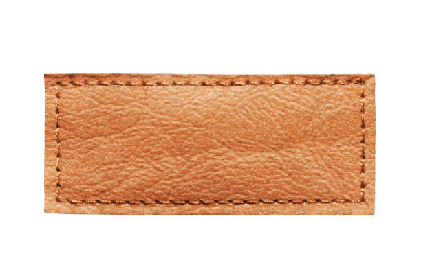 istock Brown leather belt strap closeup isolated on white. Brown stitched leather seam frame label tag isolated on white. Sewing background. 2019943009