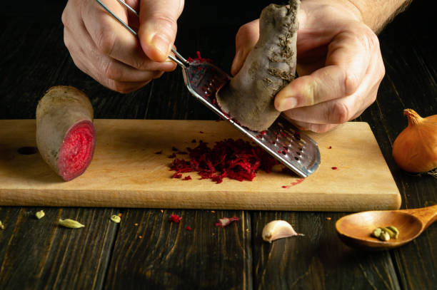 istock The chef hands grate raw beets with a grater. The process of preparing a vegetable salad or dietary dish on the kitchen table. 2019943551