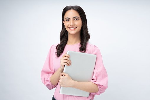 Portrait of pretty, woman holding close laptop in hands isolated on white background