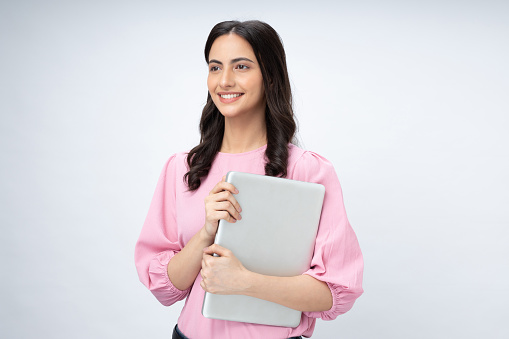 Portrait of pretty, woman holding close laptop in hands isolated on white background