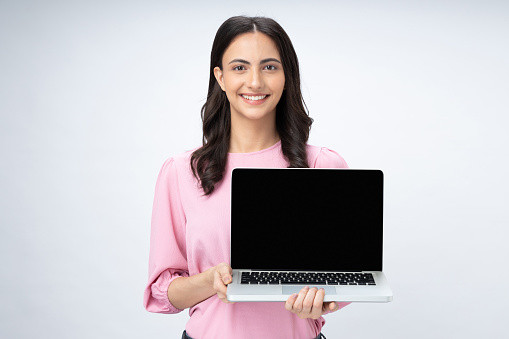 Portrait of pretty, woman showing laptop screen in hands isolated on white background