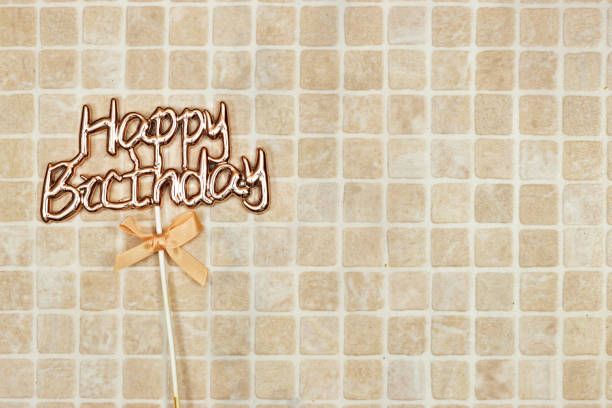 happy birthday text concept with ribbon isolated on tiles background