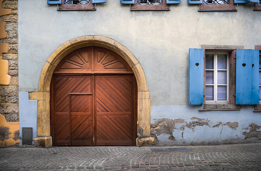 Wooden entrance gate and shutter window of an old house in the center of the medieval town of Colmar in the Alsace region of France