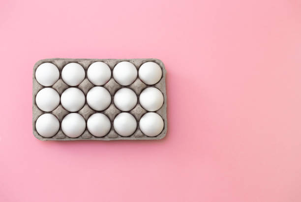istock White eggs in box close-up on pink background - stock photo 2020099036