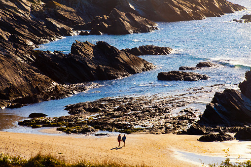 A Mariña beach, Lugo province,  Galicia, Spain. Two women silhouetted walking