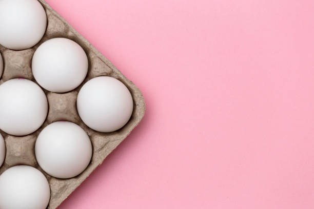 istock White eggs in box close-up on pink background - stock photo 2020110794