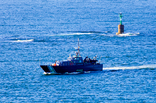A spanish customs patrol or pilot boat speeds through beautiful blue sea. Galicia, Spain.