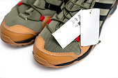 Close-up of blank footwear tag on the trekking sneakers isolated on white background