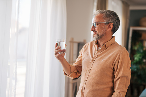 Young woman holding glass of drinking water