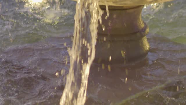 Antique fountain streaming water in sunlight, classic design in 4k slow motion 120fps