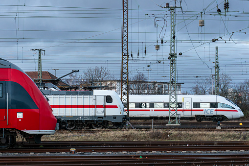 Passenger trains of various types stand on the sidings. A regional train, a regional express and an intercity train together. Traveling by train in Germany. Tracks at Leipzig Central Station.