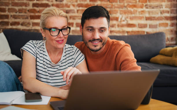 istock Smiling Couple Paying Bills Together At Home 2020183231