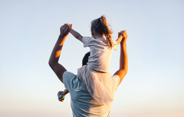 istock Back View Of A Father Carrying His Daughter On His Shoulders 2020183798
