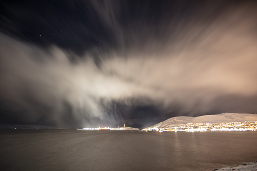 Arctic landscape with snow storm clouds at night.\nHammerfest - Norway.