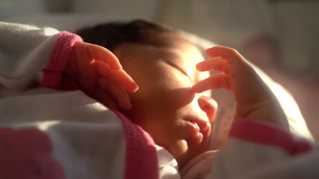 newborn baby sleeping with finger on face