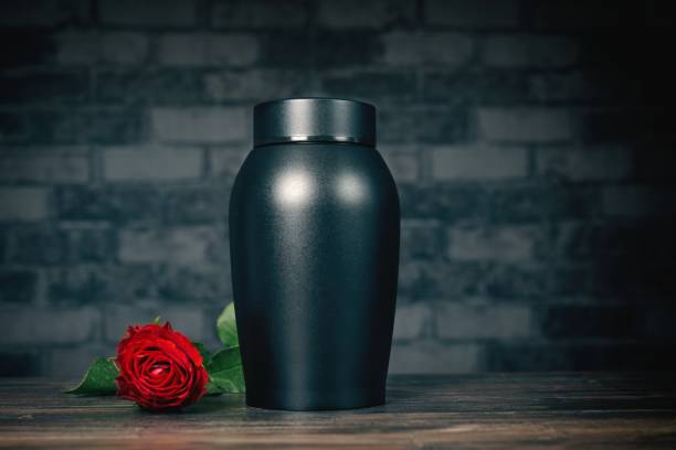 istock Funeral mourning urn next to a rose flower. 2020274608