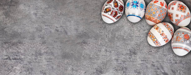 istock Happy Easter card. Colorful shiny easter eggs on gray wooden table background. Copy space for text. Banner 2020292181