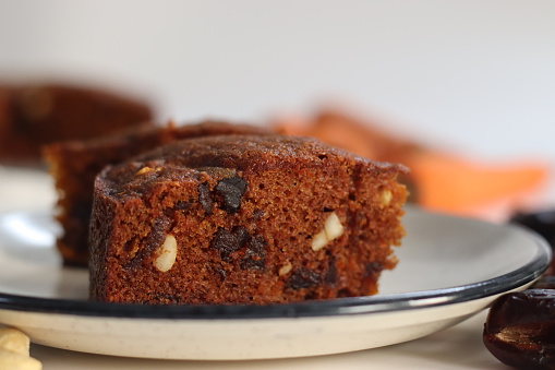 Carrot and date cake. Delicious, healthy and moist dessert. Perfect for vegan, gluten free, paleo diets. For celebrations and guilt free indulgence. Shot with carrots and dates on white background