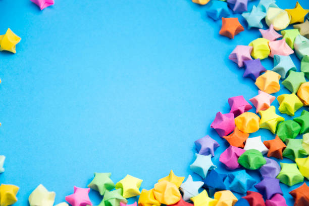 Paper folded into the shape of a multi-colored 5-pointed star, on a blue background.