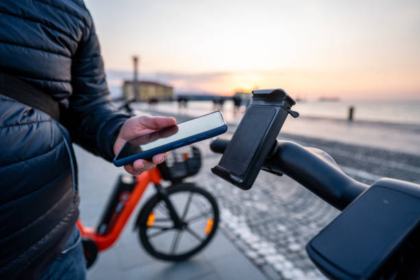 istock Hand of man renting bicycle through mobile phone on footpath horizontal still 2020391090