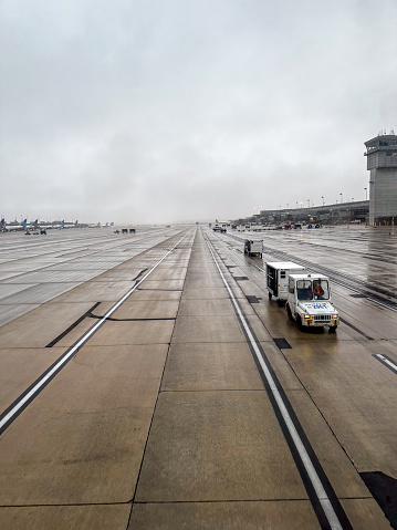 Dulles International Airport, IAD, Washington D.C., USA - United Airlines Baggage tractor on the Taxi way on a rainy day
