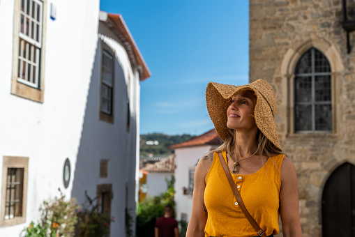 A Portuguese woman on vacation visiting Obidos in Portugal on a sunny day of summer.