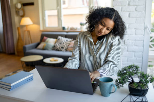 istock Woman chatting on mobile phone while typing on laptop 2020435260