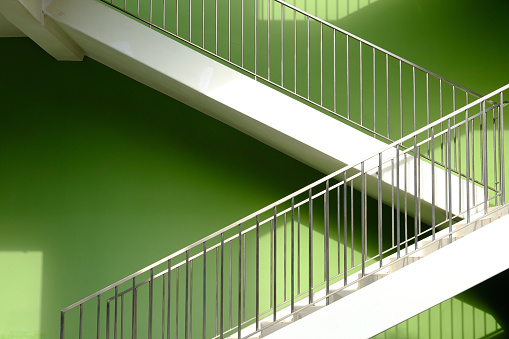 Huge first floor sign in the staircase. Concrete walls and steel handrail