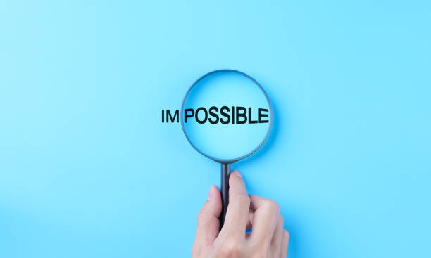 istock Hand holding magnifying glass focuses on possible from the word impossible on a light blue background. possible motivational inspirational, Business metaphor concept, looking on good side, optimism, 2020485558