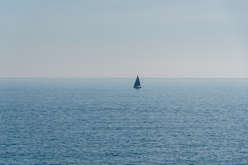 sailboat with the sea calm and the horizon in the background