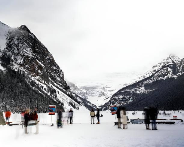 istock a group of people walking along a snowy path with snow 2020501003