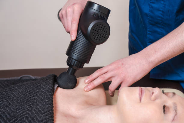 istock masseur massages a girl with a percussion massager 2020510189