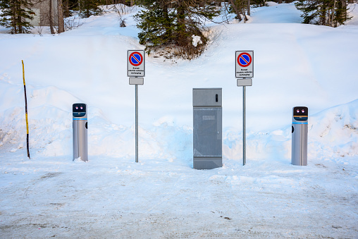 Charging station for electric vehicles in a snow covered parking lot at a ski resort in the Alps in winter