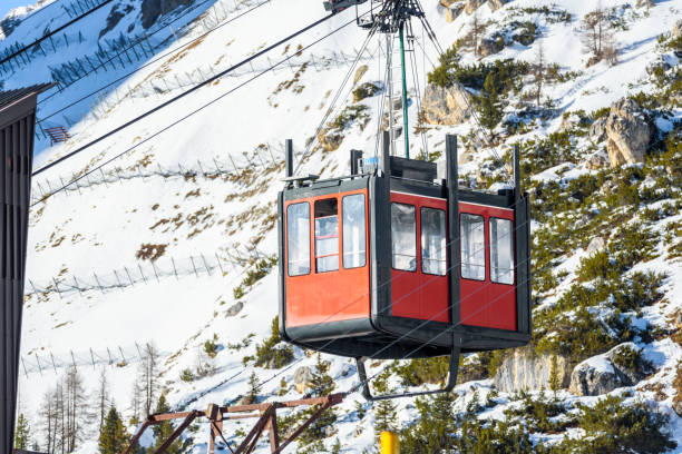 overhead cable car cabin arriving at the lower station on a sunny winter day - overhead cable car dolomites italy snow imagens e fotografias de stock