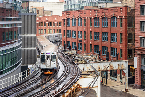 Chicago commuter train on elevated winding tracks in downtown on a rainy spring day. Illinois, USA.