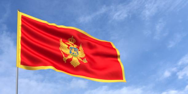 istock Montenegro flag on flagpole on blue sky background. Montenegrin flag fluttering in wind against a background of sky with white clouds. Place for text. 3d illustration. 2020544485